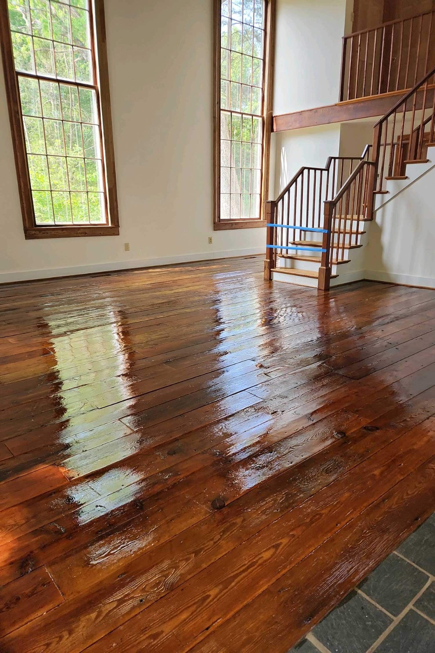 Dark stained hardwood floor beside a white fireplace, refinished by Buff & Coat Virginia